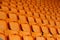 Rows of vacant orange fold up stadium seating