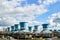 Rows of water fan cooling towers for cooling circulating water of chemical plant under cloudy blue sky. Petrochemical plant