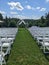 rows of white chairs are lined up and in an outdoor wedding ceremony setting