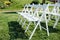 Rows of white folding chairs on lawn