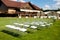 Rows of white transparent chairs on green lawn before a wedding ceremony in summer