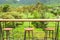 Rows of wooden stools and counter bar on outdoor terrace with beautiful landscape viewpoint.