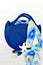 Royal blue knitted beach handbag with floral scarf background