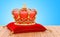 Royal Crown on the red velvet pillow on the wooden table.