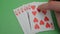 Royal flush in the hands of a professional poker player. The poker player checks his cards before increasing the bet. A