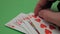 Royal flush in the hands of a professional poker player. The poker player checks his cards before increasing the bet. A