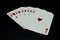 Royal flush straight flush of hearts cards in poker game against black background