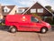 Royal mail post red van parked side view