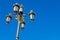 The Royal Palace, Madrid, Spain. Luxury goldish street lighting system on blue sky