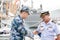 Royal Thai navy officer in white uniform shakes hand with PLAN officer in blue digital camouflage pattern uniform