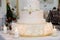 Royal white wedding cake with natural flowers and candles burning