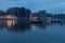 Rriver port with warehouses for unloading and loading grain at night in reflections from the water and lights