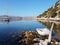 The rubber boat is tied to an old snag on the background of a picturesque bay buried in greenery of a coniferous forest with a yac