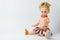 The rubber doll sits on a white background on the right side. Children`s toy. There is space for text