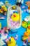 Rubber duck in the bathtub, colorful background with shells, rose petals and other rubber ducks, rubber ducks