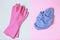 Rubber gloves and a rag on blue and pink background, top view, cleaning concept