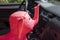 Rubber inflatable pink elephant animal toys on the front seat of a car, background with shadow reflection