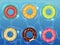 Rubber rings set on the background of water with donut, watermelon, orange, lime. Swimming ring colorful rubber toy