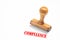 Rubber stamp with compliance sign on white background