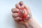 Rubber toy antistress in a woman`s hand on a white background