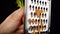 Rubbing the carrot on metal grater on black background