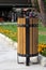 Rubbish bin in the park in summer. Turkish wooden trashcan outdoor, urn for garbage, wastebasket and grass with flowers