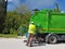 Rubbish cleaner man working green truck