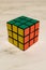 Rubik`s Cube on a marble plate, showing green, yellow and orange