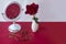 Ruby necklace and gemstone earrings are on table next to white vintage mirror and rose flower. Women`s jewelry, beautiful