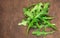 Ruccola leaf on wooden table, heap of fresh green arugula leaves collection top view