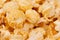 Ruddy golden popcorn closeup with blur background.