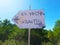 Rudimentary road signs sign indicate the way to Es Vedra and to Atlantis among the green trees and the vegetation of ibiza