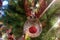 Rudolph red nose reindeer glass hand made christmas ball on xmas tree detail blur lights