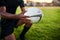 Rugby is my life. an unrecognizable sportsman crouching alone and holding a rugby ball before an early morning practice.