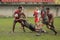 Rugby tackle on muddy field