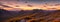 Rugged beauty of a mountain range at golden hour, with the sun setting in the background