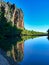 A rugged, eroded rocky outcrop reflected in a freshawater pool in Australia