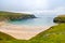 Rugged landscape at Malin Head, County Donegal, Ireland. Beach with cliffs, green rocky land with sheep on foggy cloudy