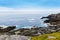 Rugged landscape at Malin Head, County Donegal, Ireland. Rough beach with cliffs, green rocky land with sheep on foggy