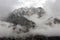Rugged Mountain Peak Shrouded In Storm Clouds