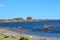 Rugged rocks jut out into the calm sea at a deserted beach on the Cook Strait near Wellington, New Zealand