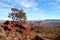 Rugged, rocky desert landscape with hills, boulders and trees in Australia