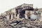 Ruined abandoned industrial building with large pills of concrete garbage, aftermath of disaster, hurricane, earthquake or war