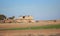 Ruined building in the field. Stone structure in the field next to the tree. Stone and damaged structure in the field.