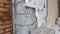 Ruined corner of the house close-up. Aerated concrete and red brick wall. Wall covered with styrofoam