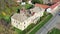 Ruined medieval castle in a small village shot by a drone from high above