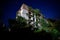 Ruined overgrown apartment house with bullet marks in night ghost town, consequences of war in Abkhazia