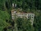 Ruined overgrown school in ghost mining town Akarmara, consequences of war in Abkhazia, aerial view from drone