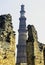 Ruined Quwwat ul-Islam Mosque with Qutb Minar tower in background at Qutub Minar complex