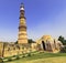 Ruined Quwwat ul-Islam Mosque with Qutb Minar tower in background at Qutub Minar complex